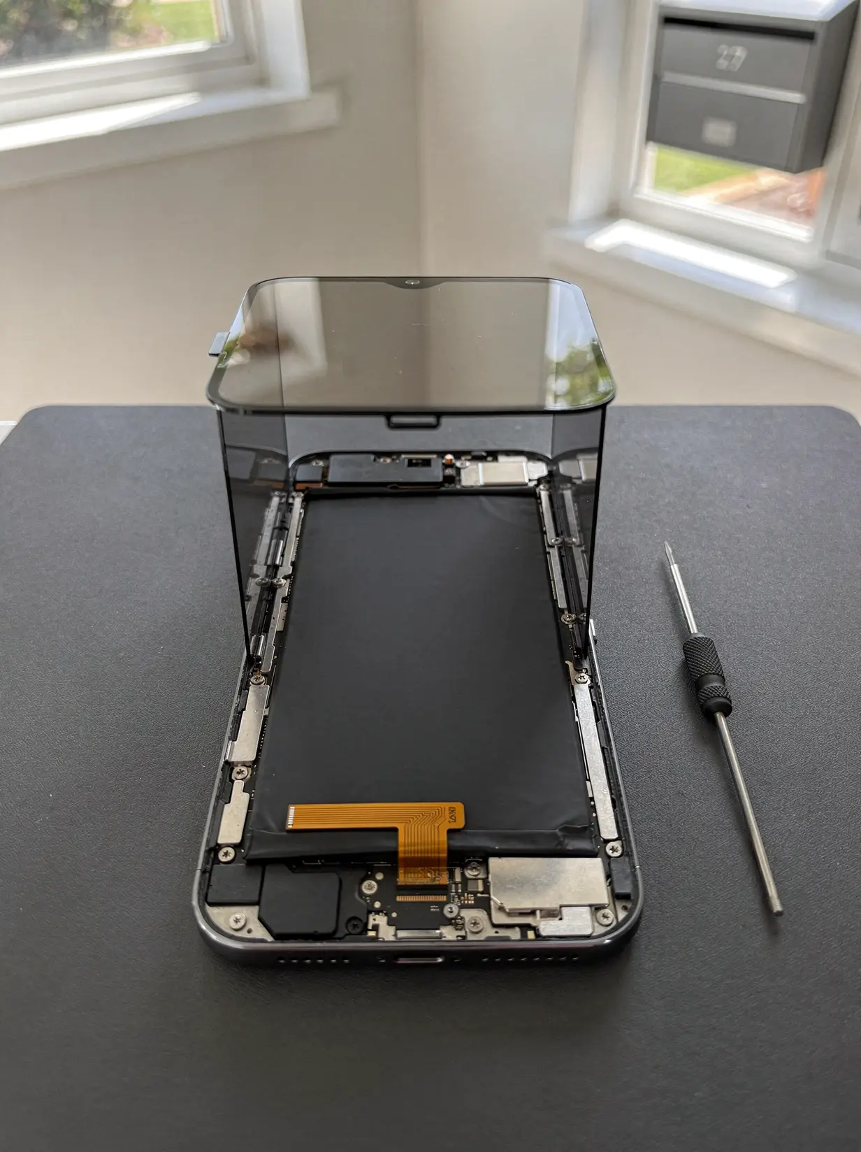 Open smartphone with new battery seated during repair in West Perth.